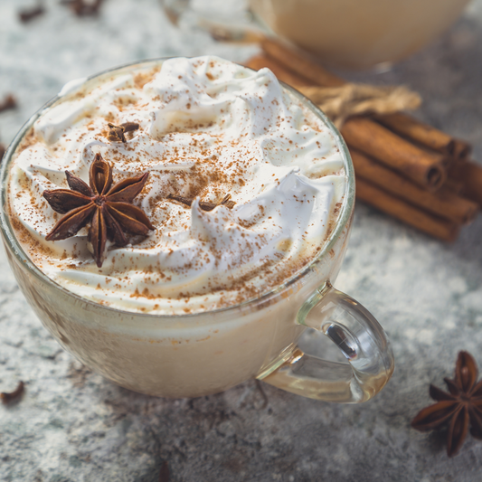 Glaskopp med drickchoklad och vispad grädde, stjärnanis på toppen.