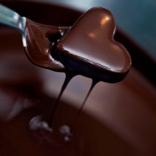 Hjärtpralin omgiven av smält choklad.